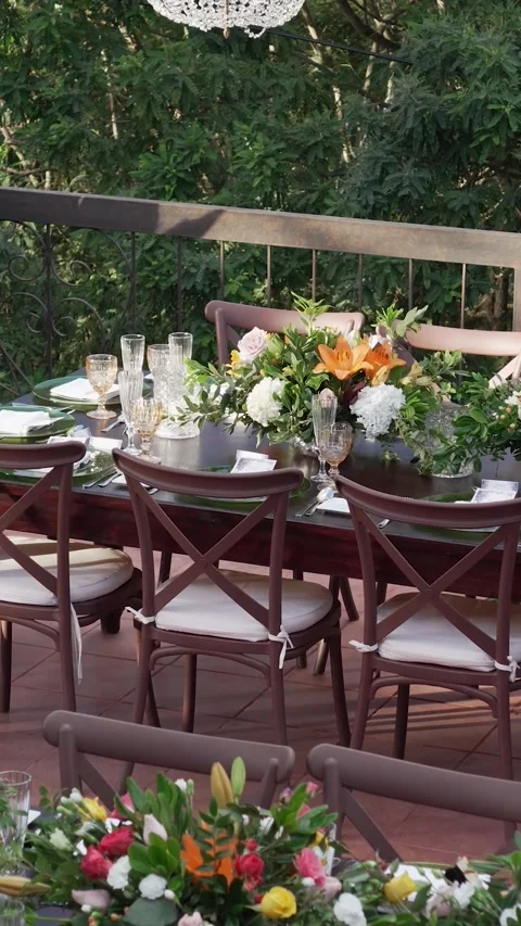 Large table with many chairs and crystal chandelier above it. The table is set Stock Footage 345111283