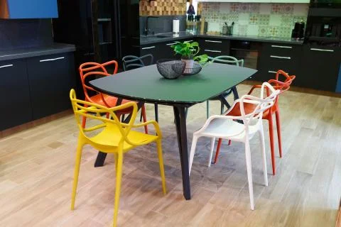 A large table in the middle of the kitchen with six chairs. Stock Photos