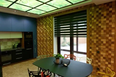 A large table in the middle of the kitchen with six chairs. Stock Photos