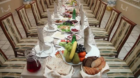 A large table with tables and chairs, Bottles, bowls spoons forks. Video stock 49446674
