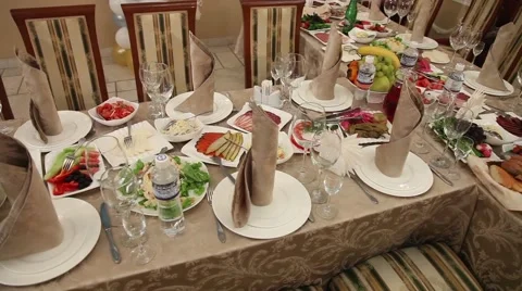 A large table with tables and chairs, Bottles, bowls spoons forks. Stock Footage 49446752