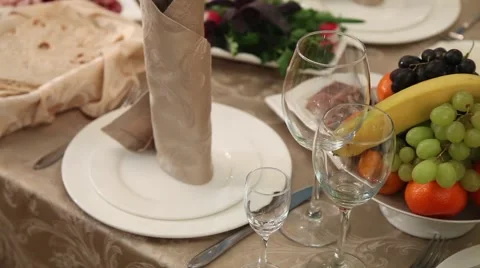 A large table with tables and chairs, Bottles, bowls spoons forks. Stock Footage 49446786