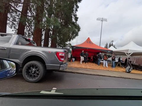 Large tailgating area features event tents, tanbark-covered ground Fotos Stock