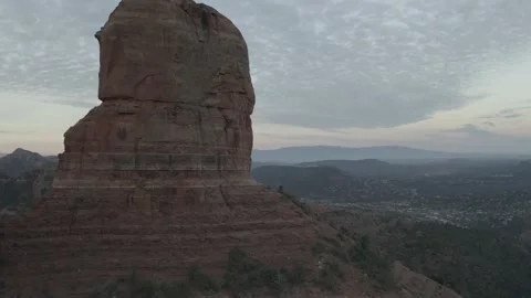 Large tall rock formation at sunset with western town behind Video stock 161443334