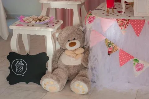 A large teddy bear sits on the floor near a hundred Stock Photos