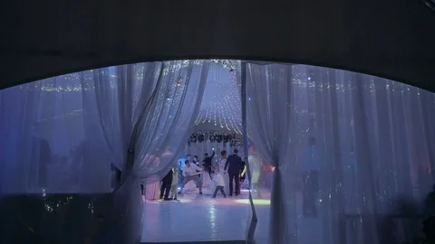  large tent with light bulbs and dancing people view from far Stock Footage 124247381