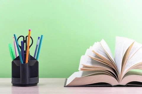 A large thick book with the pages spread out like a fan and a stand with pens Stock Photos