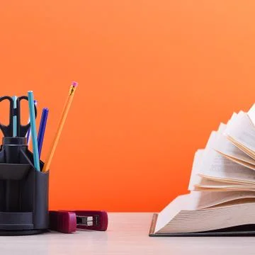 A large thick book with the pages spread out like a fan and a stand with pens Stock Photos