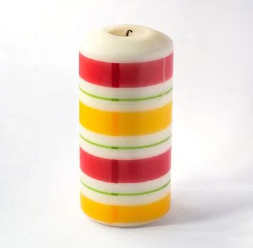 Large thick candle with colored horizontal stripes Isolated on a white backgr Stock Photos