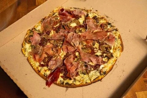 Large thin crust pizza pie covered in delicious ham, cheese, and sauce in t.. Photos