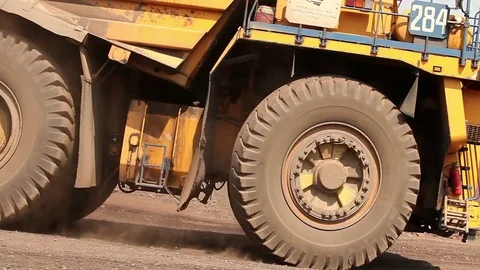 A large tipper digs through a career, an industrial truck dredges cargo in its Видео 76354465