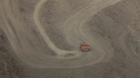 A large tipper digs through a career, an industrial truck dredges cargo in its Stock Footage