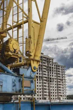 A large tower crane at a construction site against the backdrop of a modern m Stock Photos