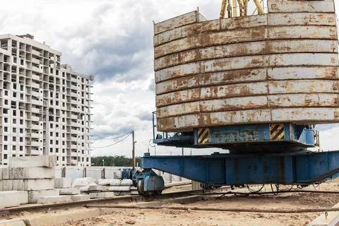 A large tower crane at a construction site against the backdrop of a modern m 库存照片