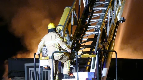 Large tower ladder turning by itself while fireman standing on base Video stock 129987639