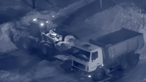 A large tractor clears the city's roads from snow. Folds snow in a big truck. Ni Stock Footage 86655096