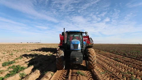 Large tractor plowing fields in bright sunny weather on a farm in a rural area Stock Footage 302630798