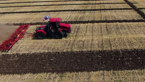 A large tractor plows a field before sowing Stock Footage 123045907