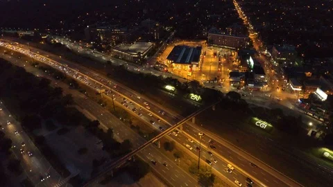 Large transit station lit by yellow spotlights on side of a freeway at night Stock-Footage 116244571