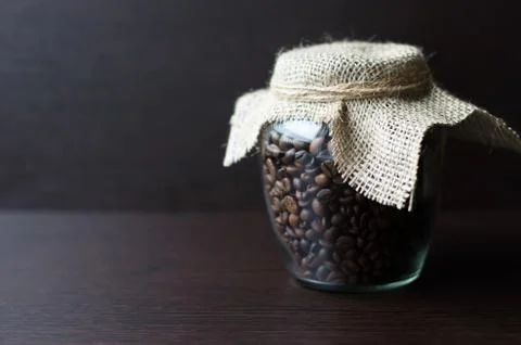 Large transparent jar with coffee beans closeup Stock Photos