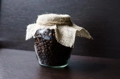 Large transparent jar with coffee beans closeup Stock Photos