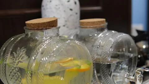 Large transparent jar of orange lemonade on a table outside Stock Footage 310187353