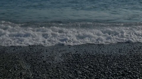 Large transparent waves with foam. Sea pebble beach with colorful stones 库存影片 80048345