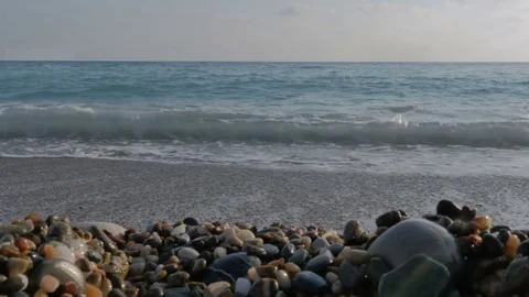Large transparent waves with foam. Sea pebble beach with colorful stones Stock Footage 80073178