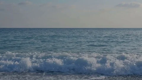 Large transparent waves with foam. Sea pebble beach with colorful stones Stock Footage 80073439