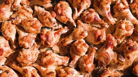 A large tray filled with baked chicken wings is displayed, showcasing their Stock Footage 338290512