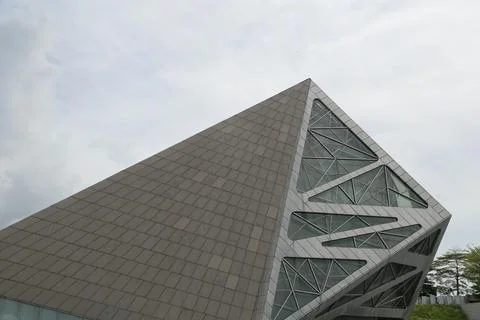 A large triangular building with a glass facade stands on the right side of.. 写真素材