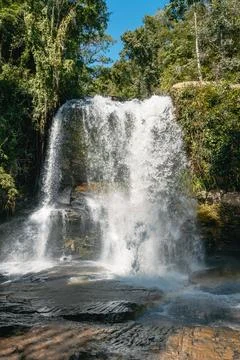 Large tropical waterfall flowing down rocks in a green forest Stock Photos