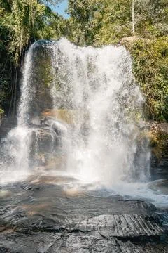 Large tropical waterfall flowing down rocks in a green forest Stock Photos