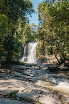 Large tropical waterfall flowing down rocks in a green forest Stock Photos