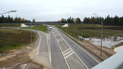 Large trucks drive under the bridge. Construction of a new road on the bridge Stock Footage 95183537
