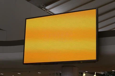 A large TV or projector screen with an orange background in screen. Stock Photos