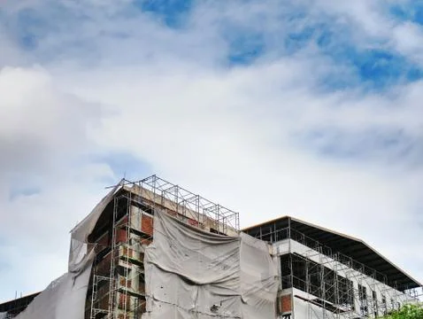 Large Under Construction Building with Frames and Covers Against Cloudy Sky Stock Photos