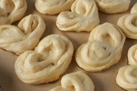 Large vanilla buns on baking paper. Selective focus. Yeast dough. Stock Photos