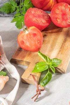 Large variety of tomatoes on rustic kitchen counter. Preparation of tomato sa Stock Photos