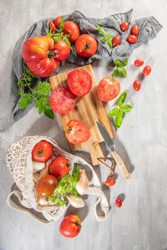 Large variety of tomatoes on rustic kitchen counter. Preparation of tomato sa Stock Photos