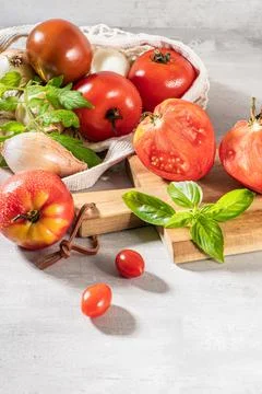 Large variety of tomatoes on rustic kitchen counter. Preparation of tomato sa Stock Photos