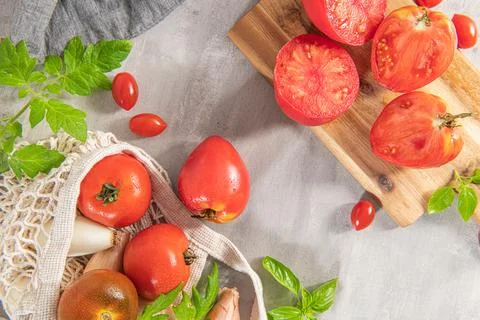 Large variety of tomatoes on rustic kitchen counter. Preparation of tomato sa Stock Photos