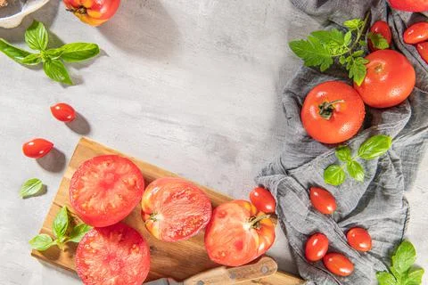 Large variety of tomatoes on rustic kitchen counter. Preparation of tomato sa Stock Photos