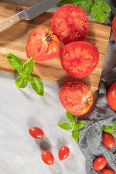 Large variety of tomatoes on rustic kitchen counter. Preparation of tomato sa Stock Photos
