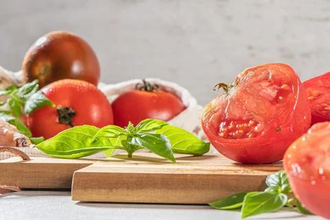 Large variety of tomatoes on rustic kitchen counter. Preparation of tomato .. Stock Photos