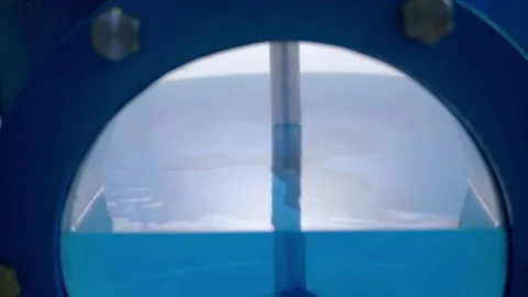 In a large vessel, an impeller slowly rotates in a blue solution Stock Footage 340465267