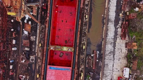A large vessel sits in the shipyard while workers prepare for cargo loading Stock Footage 337941345