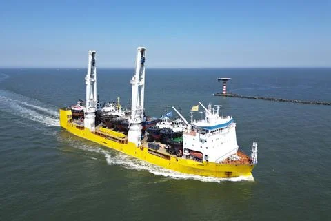 A large vessel with unique lifting capabilities carrying multiple tugboats Stock Photos