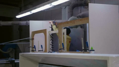 Large view of carpenter removing clamps from drying wooden surface in workroom. 스톡 동영상 296542236