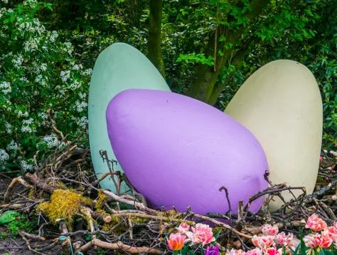 Large vivid colored easter eggs in a big birds nest, outdoor holiday decorati Stock Photos